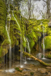 Струите се спускат по скалите покрити с яркозелен мъх