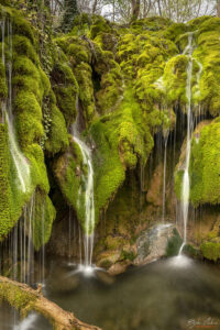 Струите се спускат по скалите покрити с яркозелен мъх